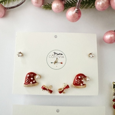 Conjunto de brincos com três pares em cartão branco com logotipo Maria Cotovia e decoração natalícia.