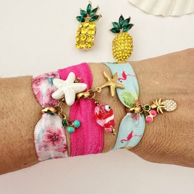 brincos de abacaxi com pedras amarelas e verdes e pulseiras coloridas com estrelas do mar