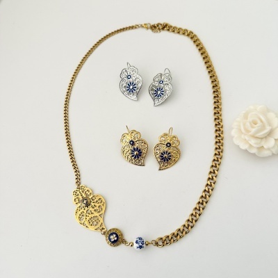 Colar dourado e dois pares de brincos com detalhes florais azuis