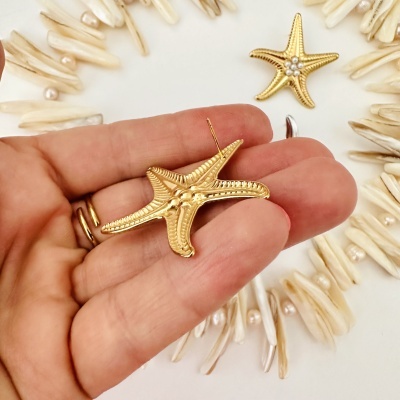 Brincos dourados estrelas do mar com pérolas e fundo branco com colar branco e pérolas
