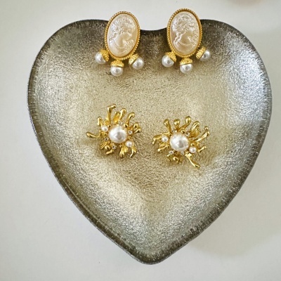 Dois pares de brincos em prato prateado em forma de coração, com camafeus e pérolas.