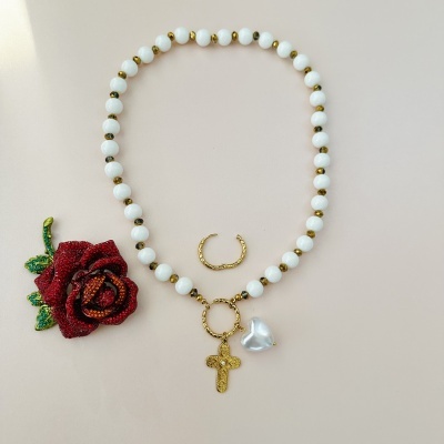 Colar branco com pendente de cruz e coração, anel dourado, broche de flor vermelha e verde