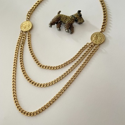 Colar dourado de três camadas com medallhões e broche em forma de cão com cristais