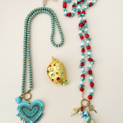 Colares e broche decorativo com tema marinho em cores azul, vermelho, dourado e branco