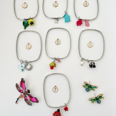 Pulseiras quadradas com pendentes coloridos e brincos libélula em fundo branco
