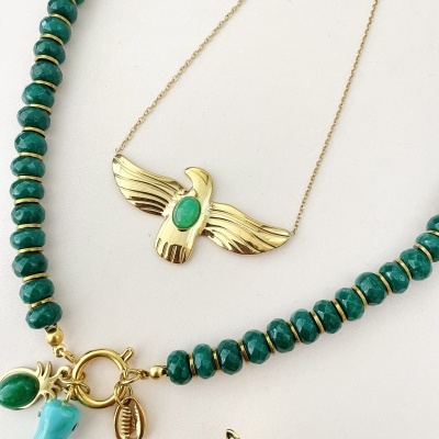 Colares com contas verdes e pendentes dourados sobre fundo branco