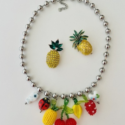 colar prata com pendentes coloridos de frutas e insetos e dois broches de abacaxi com cristais