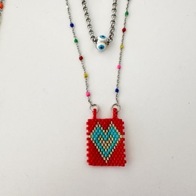 Colar com pingente retangular de contas coloridas com padrão de coração e corrente prateada com contas coloridas.
