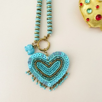Colar com pendente em forma de coração azul decorado com lantejoulas e contas douradas