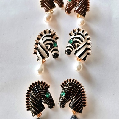 Três pares de brincos em forma de cabeça de cavalo com pérolas penduradas