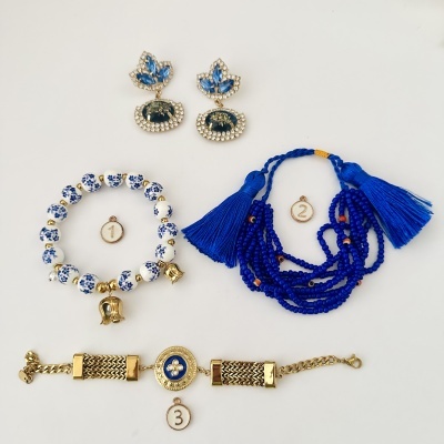 Acessórios de bijuteria com pulseiras e brincos em várias tonalidades de azul e dourado sobre fundo branco