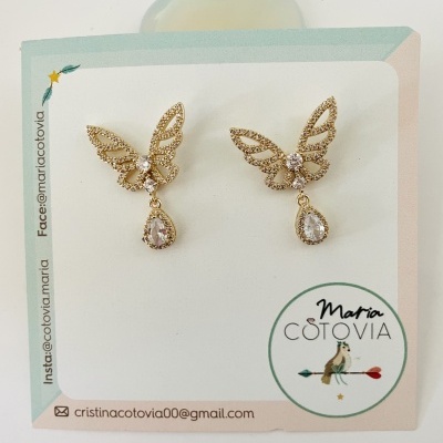 Brincos dourados com cristais em cartão de apresentação com logo Maria Cotovia