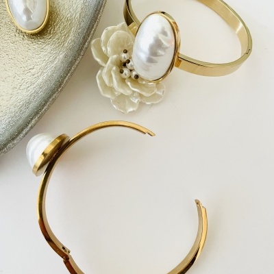 Braceletes dourados com pérolas grandes e flor branca decorativa