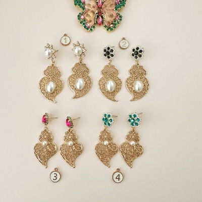 Quatro pares de brincos dourados com pérolas e pedras coloridas, numerados de 1 a 4, e borboleta decorativa rosa e verde