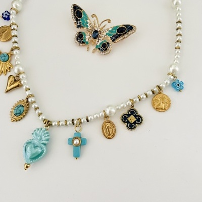 Colar com pendentes variados e broche borboleta em fundo branco