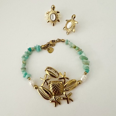 Conjunto de brincos e pulseira com tartarugas douradas e contas verdes.