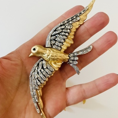 Escultura decorativa de pássaro dourado e prateado na palma da mão