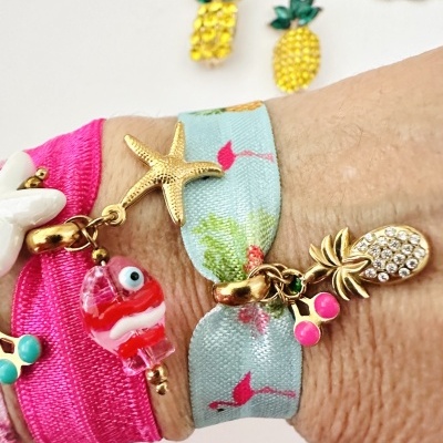 Pulseiras coloridas com pendentes dourados no pulso