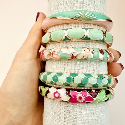 Conjunto de seis pulseiras coloridas com motivos florais e padronagem hexagonal em suporte de tecido