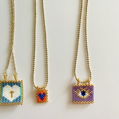 Três colares com pingentes quadrados de contas coloridas e correntes douradas