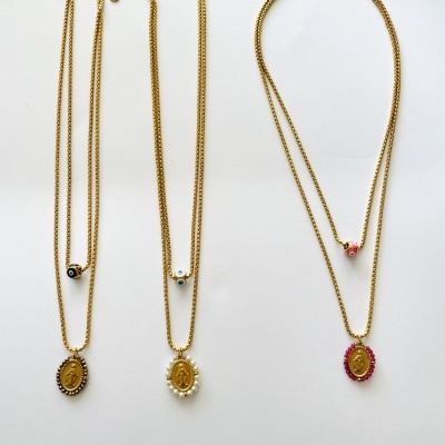 Três colares dourados com pendentes ovais decorados em fundo branco
