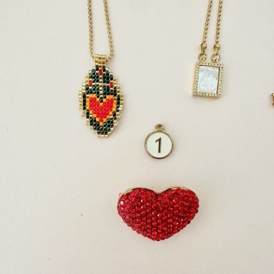 Quatro acessórios e joias com coração, colares e pingente com número 1.