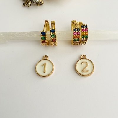 Brincos dourados com pedras coloridas e pendentes numerados 1 e 2