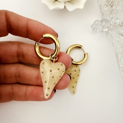 Brincos de argola dourada com pendente de coração bege com relevos dourados