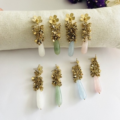 Brincos pendentes com metal dourado e pedras coloridas em branco, verde, azul claro e rosa.
