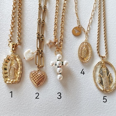 Cinco colares dourados com diferentes pendentes religiosos e decorativos
