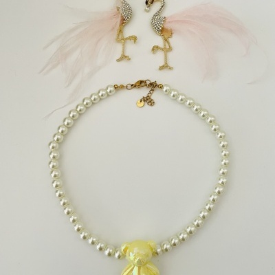 Colar de pérolas com pendente de ursinho amarelo e brincos flamingos dourados com penas cor-de-rosa
