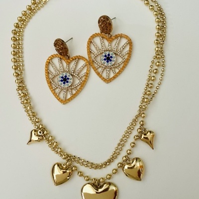 Colar dourado com cinco corações e brincos em forma de coração com padrão azul e branco no centro