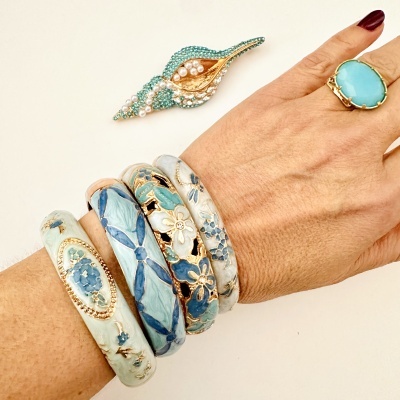 Pulseiras florais em azul e bege, anel azul dourado, broche com pérolas e cristais