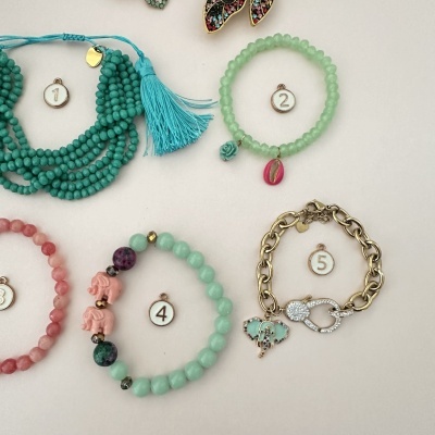 Cinco pulseiras coloridas numeradas sobre fundo branco