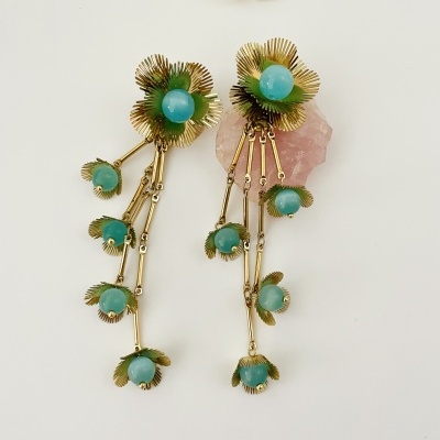 Brincos compridos dourados com pedras verdes e base flor branca