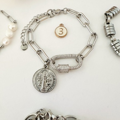 Pulseira prateada com pingente redondo e fecho brilhante