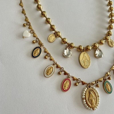 Colares dourados com medalhas religiosas e contas sobre fundo branco