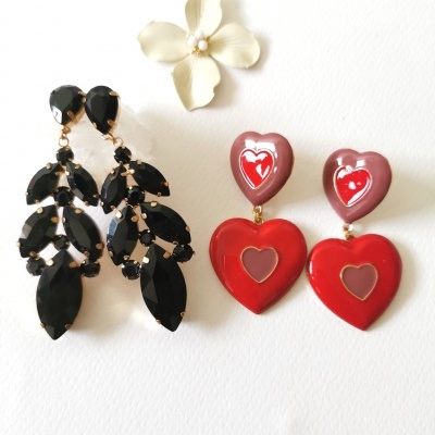 Dois pares de brincos, um com pedras pretas facetadas e outro com corações vermelhos e rosa