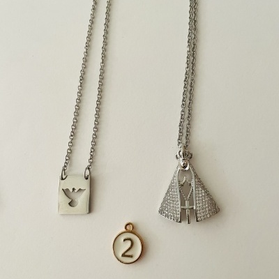 Dois colares prateados e medalhão com número 2