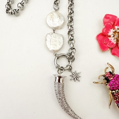 Colar prateado com pendentes de perlas, dente cravejado de pedras e estrela brilhante