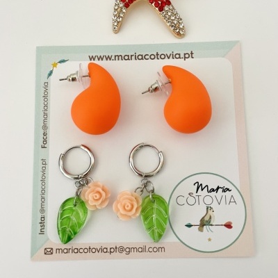 Dois pares de brincos coloridos sobre cartão com logótipo Maria Cotovia