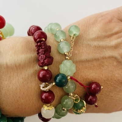 Pulseiras coloridas com contas redondas e flor esculpida no pulso