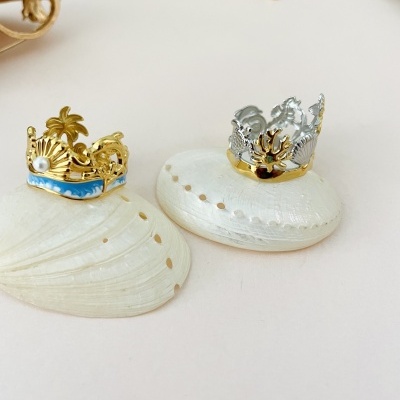 Anéis de metal dourado e prateado com conchas brancas