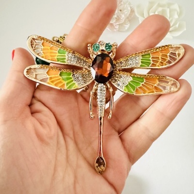 Broche decorativo em forma de libélula com asas coloridas e pedras brilhantes