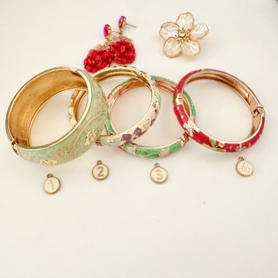 Pulseiras coloridas esmaltadas com acessórios decorativos e pingentes numerados.