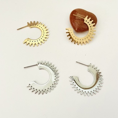 Dois pares de brincos meia argola dentados, um dourado com pedra castanha, outro prata, ambos sobre fundo branco