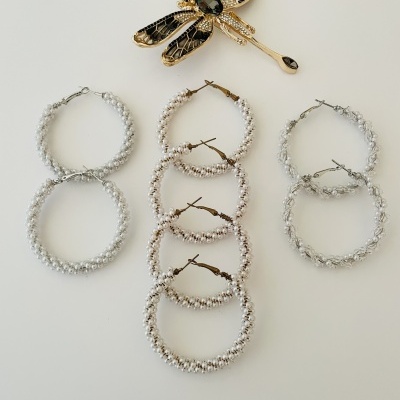 Três pares de brincos de argola prateados texturizados e alfinete de peito dourado em forma de libélula