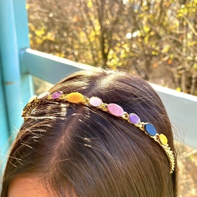 Tiara dourada com pedras coloridas usada na cabeça