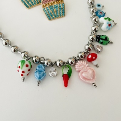 Brincos de cupcake com pedras coloridas e pulseira com pendentes variados coloridos