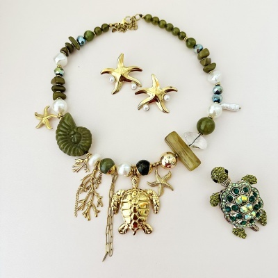 Colar com contas verdes e brancas e pingentes dourados com tema marinho, com brinco estrela-do-mar